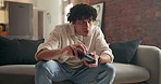 Man, video game and relax on sofa in home with online competition, challenge and click in lounge. Person, controller and contest for next level, console and gamer on couch in living room at apartment