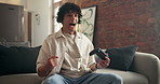 Happy man, winning and gamer with headset on sofa for match victory or celebration in home. Excited, male person or winner playing on entertainment console for esport score, point or game achievement