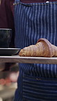 Waiter, croissant and coffee cup on board in cafe, hospitality industry and breakfast order for serving. Customer service, pastry or person with tray to deliver tea beverage, closeup and morning meal