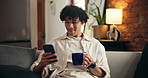 Home, coffee and happy man on sofa, cellphone for social media and message to contact. Connection, herbal tea or person on couch, relax and smartphone for online reading and website for entertainment