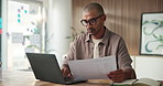 Business, man and laptop with document in office for research, editing article and proofreading. Male person, pc and interview paperwork for story manuscript, copywriting report and editor feedback