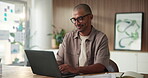 Creative, laptop and man with glasses, office and research for ad campaign on website or copywriting. Online, typing and person with technology for article, email marketing and happy with project