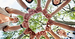 Low angle, fist bump and people in forest, smile and team building for support. Below, friends and men with women, celebration and gesture for unity, motivation and collaboration for group activity