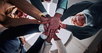 Below, teamwork and business people in office with hands together, solidarity or motivation for goals. Happy, colleagues and huddle in workplace with connection, collaboration or synergy for success.