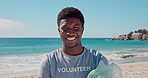 Volunteer, face and man with trash, beach and smile for social responsibility, cleaning or recycling. Happy, black person and waste removal for wildlife protection, pollution and community service