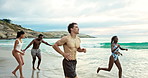 Friends, running and people on beach on weekend for summer vacation, holiday and freedom. Happy, energy and men with women in waves, ocean and nature for fun, tropical adventure and bonding on trip