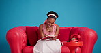 Studio, black woman and writing in notebook on sofa for funny idea, to do list or planning schedule. Couch, smile or person with diary for notes, reminder or laugh with inspiration on blue background