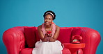 Thinking, smartphone and black woman on sofa in studio, relax and message to contact. Mobile user, smile and African person on couch, cellphone for social media, app and decision on blue background