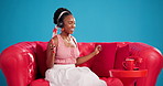 Dance, streaming or black woman in studio with headphones, audio app or listening to music playlist. Movement, sofa or person with tech, feeling beat or radio subscription on blue background.