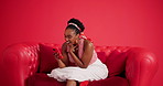 Surprise, smartphone or black woman on sofa in studio, expression or social media. Gossip, smile or African person on couch, cellphone for online news or app for announcement or wow on red background