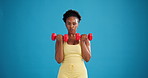 Black woman, face and exercise with dumbbells in studio for fitness, workout and blue background. Portrait, weightlifting and strength training with person for bicep muscle, power and mockup space