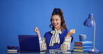 Happy woman, laptop and dancing with good news in studio for winning on a blue background. Excited, female person or employee with smile or fist pump on computer for business success or achievement