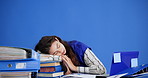 Woman, sleeping and documents with stress in studio for overworked pressure on a blue background. Tired, female person or asleep with overwhelmed paperwork for burnout, fatigue or workload on space