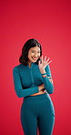 Wave, face and Asian woman in studio with sportswear, hi and welcome in warm interaction. Happy, space or athlete on red background with gesture, friendly hello or greeting with hand communication.
