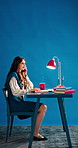Business woman, phone call and planning in office for communication, schedule or discussion. Laptop, aesthetic and talk for conversation, space and feedback for project management on blue background
