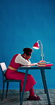 Check time, writer and black woman in studio, tired and deadline for news report on blue background. African person, space and journalist at desk, burnout and schedule for publication and fatigue