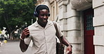 City, phone or happy man dancing with headphones for commute, streaming radio channel or music playlist. Sidewalk, listen or black person singing with audio tech for travel, smile or groove to song
