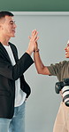Woman, man and photographer with high five at studio with motivation, goals or team at creative agency. People, producer and celebration with camera, success or excited for project at media company