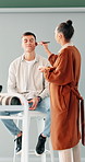 Man, woman and makeup brush for photoshoot with talk, smile or texting on break at media studio. People, cosmetic artist and model with powder, foundation or scroll on smartphone with creative career