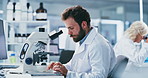 Scientist, typing and man with tablet at microscope in lab for clinical trial, disease study or innovation. Coworking, person and equipment with tech for pathology research, medical results and notes
