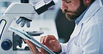 Scientist, microscope and typing on tablet in lab for clinical trial, sample testing or innovation. Coworking, man and equipment with tech for medical results, cancer research and vaccine development