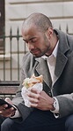Sandwich, phone and businessman on bench for lunch break, connectivity and typing message for email. Reading, eating food and employee with mobile app for texting, online chat and networking in city