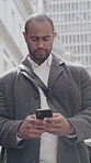 Typing, phone and businessman in city for networking, connectivity and message notification for email. Reading, low angle and employee with mobile for texting, inbox and online chat response in town
