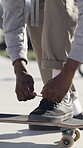 Lace, skateboard and shoe with man outdoor for hobby, practice or sports safety in summer. Active, fasten and ground with skater person tying footwear in city skatepark for skills development