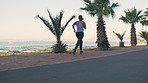 Back, woman and running for fitness at beach with exercise, training and cardio challenge. Athlete, female person and lose weight with workout, endurance performance and wellness on promenade outdoor