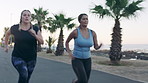 Athlete, people and running for fitness at beach with exercise, training and cardio challenge. Women, friends and lose weight with morning workout, endurance performance and race on promenade outdoor