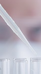 Scientist, dropper and solution in test tubes in lab for drug trial, medical research and synthesis. Eyes, person and closeup of liquid sample for science experiment, study and innovation with safety
