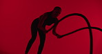 Fitness, woman and battle rope in studio for workout, strength training and cardio on red background. Exercise, strong and person with equipment for muscle development, endurance or power with health
