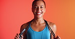 Skipping rope, fitness and face of woman in studio with workout, wellness or training for weightloss. Happy, sports and portrait of athlete with equipment for cardio exercise by orange background.