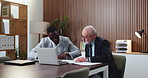Business, men and meeting with documents in office for discussion, planning and finance report. People, talking and mature man with laptop, financial paperwork and information for investment proposal