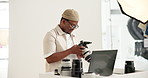 Photoshoot, laptop and black man in workplace, camera for creative project and catalog selection. Photographer, freelancer and African person in studio, pc and equipment for pictures and production