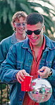 Man, friends and dancing outdoor with disco ball social gathering and rhythm at rave event. Bokeh, people and party with alcohol, listening to music and celebration with energy for festive reunion