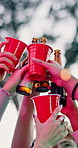 Celebration, cheers or hands outdoor with alcohol, reunion or bonding together at friendship event. Bokeh, low angle or people outside with cups, birthday party or drinks toast in social gathering.