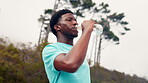 Drinking, water and man on road, fitness and hydration after workout routine, refreshing or wellness. Outdoor, runner and black person with liquid on break, low angle and exercise recovery with fluid