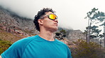 Mountain, thinking and man with sunglasses for exercise, fitness and workout for wellness. Low angle, reflection and person with eyewear ready for challenge, active hobby and training for health