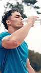 Man, runner and drinking with water in nature for hydration, workout or outdoor exercise. Active, male person or break with mineral liquid or sweat for sustainability, rest or training recovery