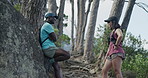 Forest, hiking or couple talk for fitness, wellness or interracial people on holiday break in nature. Trekking, man and woman with conversation in woods, smile and adventure on vacation together