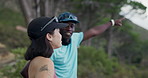 Fitness, outdoor or couple talk in forest, point or interracial people on workout break for health. Training, man and woman with conversation in woods for exercise, smile or sightseeing with view