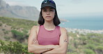 Arms crossed, hiking and serious with woman in mountains for exercise, fitness or hobby. Confident, discover and explore with hiker person outdoor in nature for activity, adventure or sports