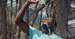 Black man, fitness and water splash with bottle in forest for hiking break, rest or hydration. Active, male person or hiker cooling off with mineral liquid or beverage for heat, recovery or trekking