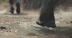 Feet, hiking and puddle with people outdoor in nature for adventure, journey or trekking. Back, walking and water splash with hikers on rugged terrain for fitness, health or wellness activity