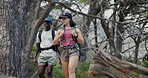 Fitness, couple and trekking on mountain with backpack, exploration and conversation for wellness goals. Low angle, people and point in nature with outdoor adventure, hiking and healthy relationship.