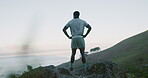 Back, hiking and summit with man outdoor in mountains for break, ocean view or sports hobby. Active, exercise and fitness with hiker person in scenic nature for adventure, challenge or training