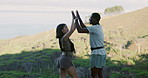 Couple, hiking and high five with people on mountain for travel, adventure and success in nature. Summit, support and celebration with woman and man outdoor for trekking, eco tourism or sightseeing