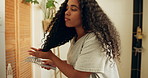 Spray, bathroom and woman with brush for hair care, curls maintenance product and grooming routine. Detangle treatment, styling and person with application for soft texture, home and getting ready