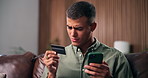 Mobile, credit card and confused man in home with payment fail, low balance or banking error. Phone, debit and person on sofa with scam, online shopping glitch or checkout problem for financial fraud